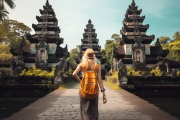 Foto op Canvas Young woman tourist with backpack standing at Pura Besakih temple in Bali, Indonesia, Tourist woman with backpack at vacation walking through the Hindu temple in Bali in Indonesia, AI Generated © Iftikhar alam