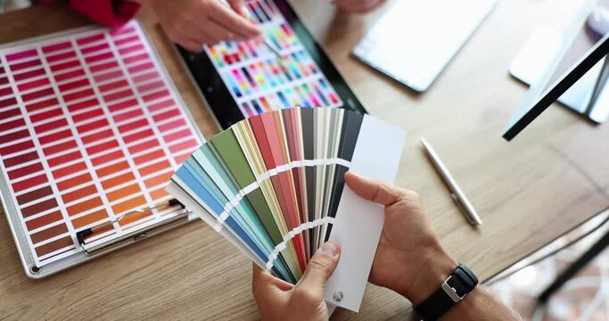 Designer and client selecting color from palette and digital tablet closeup 4k movie slow motion. Interior design concept