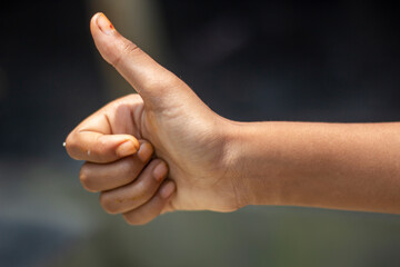 A man pointing his thumb up and blurred background