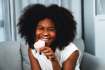 Funny beautiful young African blogger on mess face presenting cupcake in concept special cuisine....