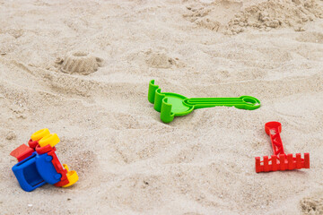 Fototapeta na wymiar Little car and other children toys for relax or playing on sand at beach. Vacation time