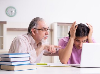 Old father helping his son in exam preparation