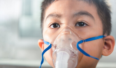 Asian Child using nebulizer mask equipment alone have smoke, Kid boy making makes inhalation...