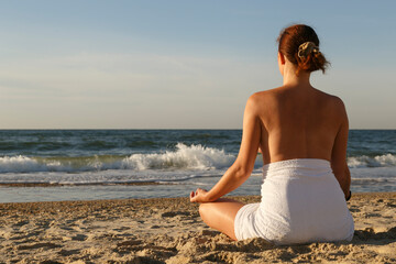 Fototapeta na wymiar Woman meditating on beach