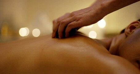 Woman, spa rocks and hot stone massage with skincare and beauty treatment for back pain. Relax, zen and wellness of female person with calm and detox for muscle on a salon bed for skin and body care - Powered by Adobe