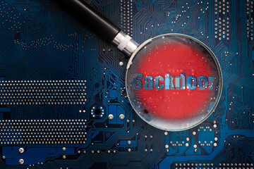 Backdoor chip on a printed circuit board through a magnifying glass.