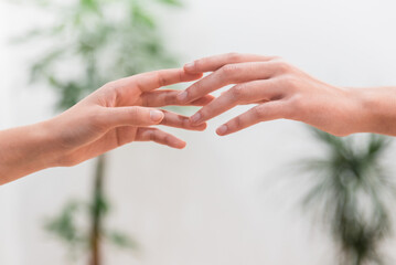 Unrecognizable people reaching out hands to each other