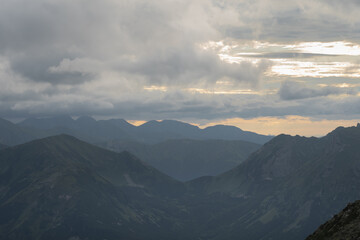 Mesmerizing mountain landscape high in the Polish Tatras at sunset through the clouds.