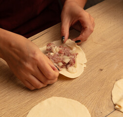 The girl makes manti on the table