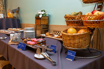 Hotel Breakfast Buffet with Fresh Fruits, Sweets, and Assorted Baked Goods in a Cozy Setting