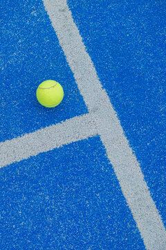ball on a blue turf court paddle tennis court