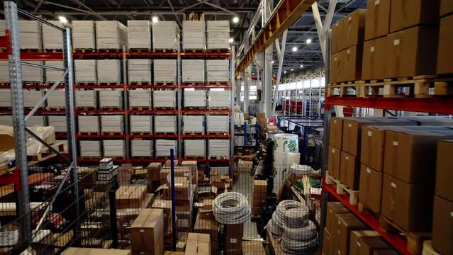 Wooden boxes on shelves inside immense industrial warehouse. Ready packaged products in spacious warehouse in industrial park
