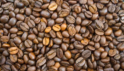 Fototapeta premium Close up of a bunch of coffee beans background top view; roasted dark brown coffe seeds
