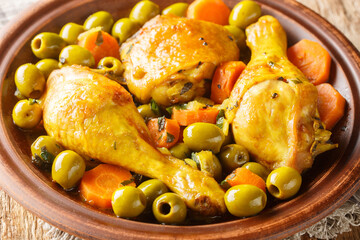 Algerian Chicken with olives and carrot Tajine Zitoune close-up on wooden table. Horizontal