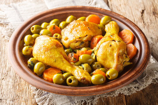 Tajine zitoune is a chicken mix vegetables ad spices cuisine close-up on wooden table. Horizontal