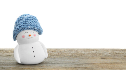 Cute decorative snowman in blue hat on wooden table against white background, space for text