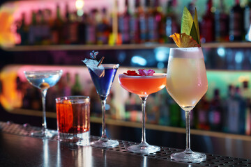 Different fresh alcoholic cocktails on counter in bar