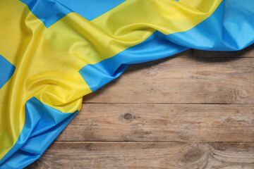 Flag of Sweden on wooden background, top view. Space for text