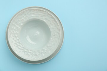 Beautiful ceramic plate on light blue background, top view. Space for text