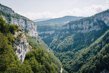 View on the Alps and the mountains of Vercors mountain range from the hiking trail of the Bourne river canyon in the French Alps (Isere) - obrazy, fototapety, plakaty