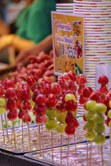 Skewers of sugar coated fruit