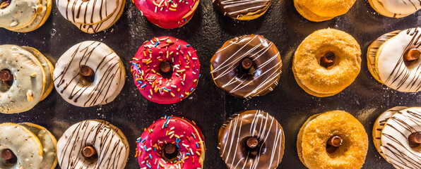 Happy idyllic breakfast closeup top view donuts pattern. Top view of assorted glazed donuts....