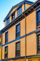 Obraz premium Facade of an old building with red frames in windows and balconies in Oviedo, Spain