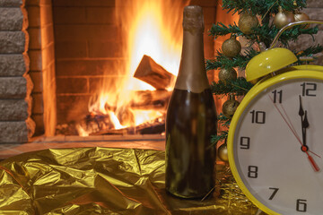 Cozy fireplace,Christmas tree decorated with Christmas balls, bottle of champagne, and retro style alarm clock .