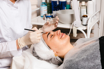 Obraz na płótnie Canvas Applying a facial mask in a skin care clinic for facial skin elasticity