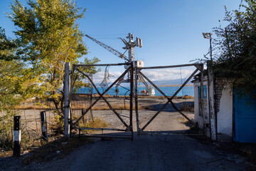 old abandoned gate to Port Balykchy on Issyk-Kul lake at sunny autumn afternoon.