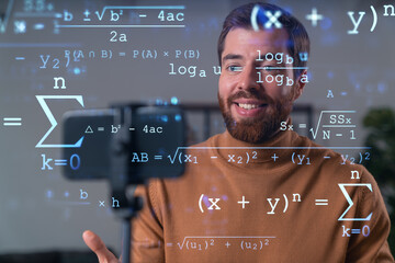 Happy man is making video blog using smartphone on a tripod explaining, teaching, master class people in room. Concept of online stream, business education, conference call.