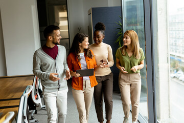 Young multiethnic startup team walking in the modern office