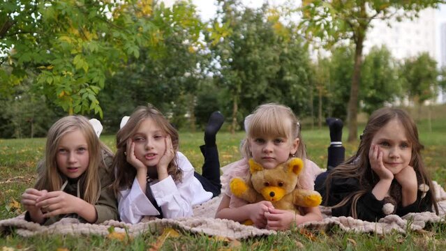 children's portrait of four little girls on a picnic in a summer park 4k