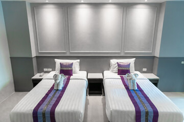 Hotel Room Decorated single double bedroom with nice white bed sheets purple decorative colours. the colour scheme is designed for thailand and interior is m modern classical