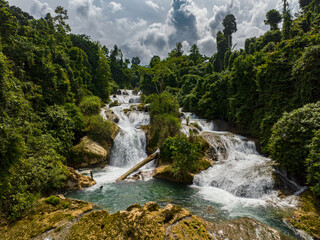 Fresh water cascades flowing between the tropical forest. Aliwagwag Falls. Mindanao, Philippines.
