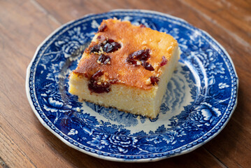 A slice of Malai, or alivenci, a cornbread-like cake from the Romanian cuisine, made with cornmeal and cheese, served with sour cream and blueberry jam