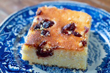 A slice of Malai, or alivenci, a cornbread-like cake from the Romanian cuisine, made with cornmeal and cheese, served with sour cream and blueberry jam