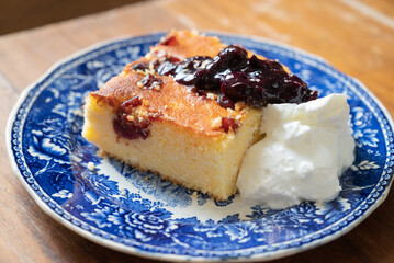 A slice of Malai, or alivenci, a cornbread-like cake from the Romanian cuisine, made with cornmeal and cheese, served with sour cream and blueberry jam