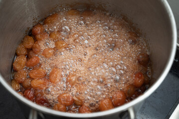 Grapes boiling in a pot with sugar, as part of the process of making homemade jam