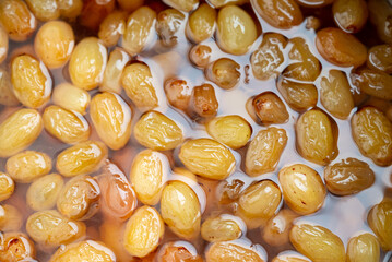Grapes boiling in a pot with sugar, as part of the process of making homemade jam
