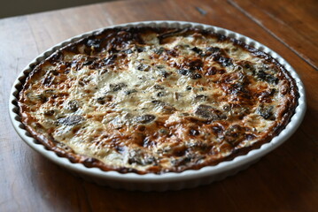 Mushrooms quiche, a French style tart consisting of pastry crust filled with savory custard and pieces of cheese and Champignon mushrooms 