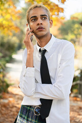 Attentive young black urban boy talking on his cell phone in the street