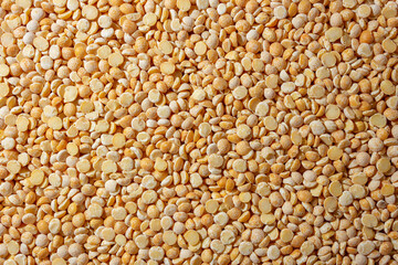 Uncooked Polished Split Peas Background. A Culinary Canvas of Dry Yellow Peas, Creating a Lively and Textured Background for Gourmet Cooking. Scattered Raw Polished Peas. Healthy Eating Ingredients