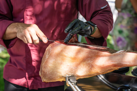 Manos de maestro jamonero cortando jam&oacute;n al aire lebre