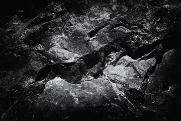 Close-up black and white worn textured stone surface background. Rock texture detail. Geology and...
