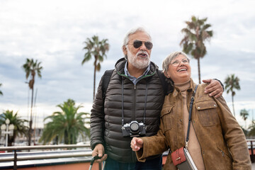 Fototapeta premium Happy old couple tourists traveling together - Grandpa and grandma on a retirement trip 