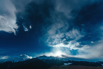 Dramatic mountain landscape with snowy peaks sky