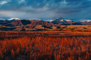 Picturesque autumn landscape with mountains at red sunset light
