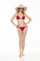 Full body, front view young blond smiling woman in bikini and hat posing on white background