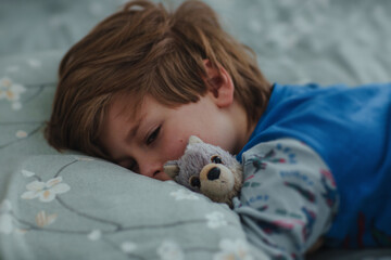 Little boy with toy sleeping in his bed early in the morning - 687495763